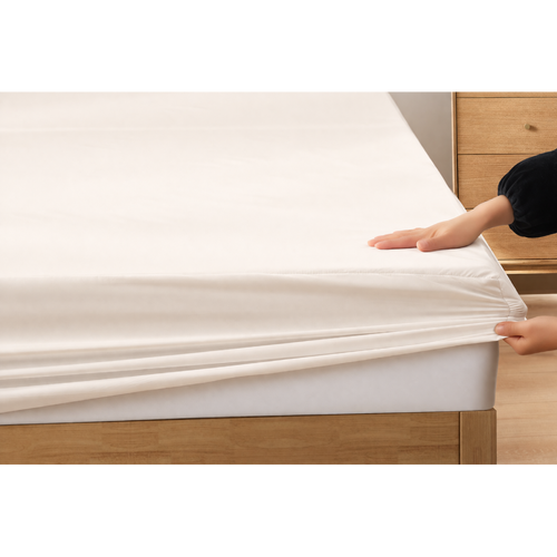 Woman bedding silky-soft white ivory fitted eucalyptus sheets with breathable and hypoallergenic comfort.